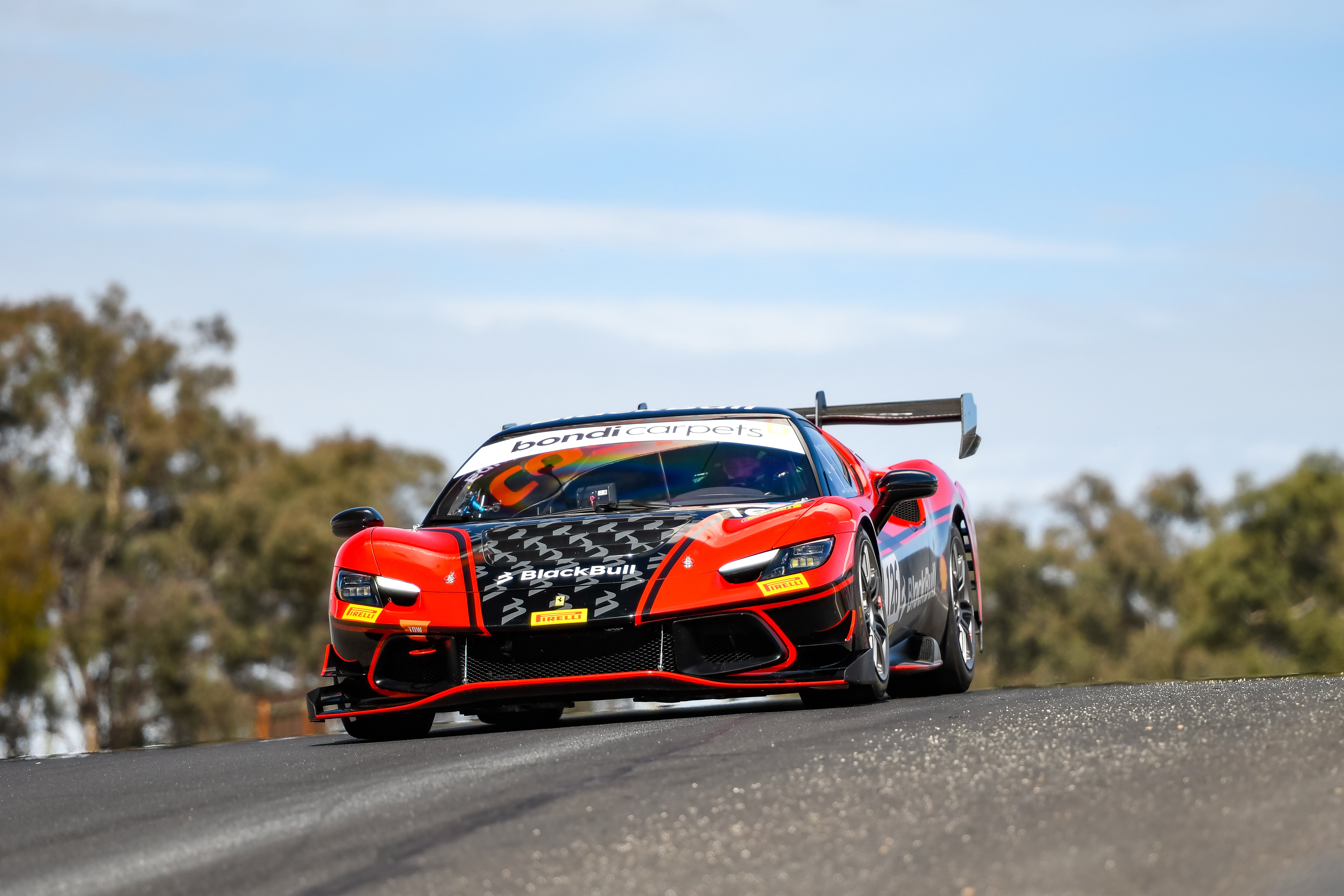 Red and Black Ferrari Challenge 296 racing at challenge bathurst at mount panorama circuit.