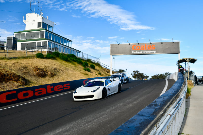 White Ferrari Challenge Race Car driving on the Mount Panorama Circuit at Bathurst