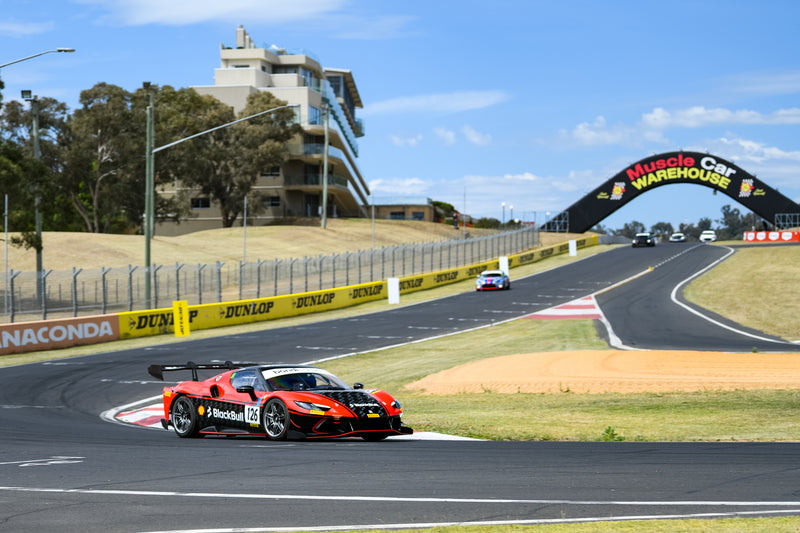 Red and Black Ferrari Challenge racing at mount panorama, bathurst.