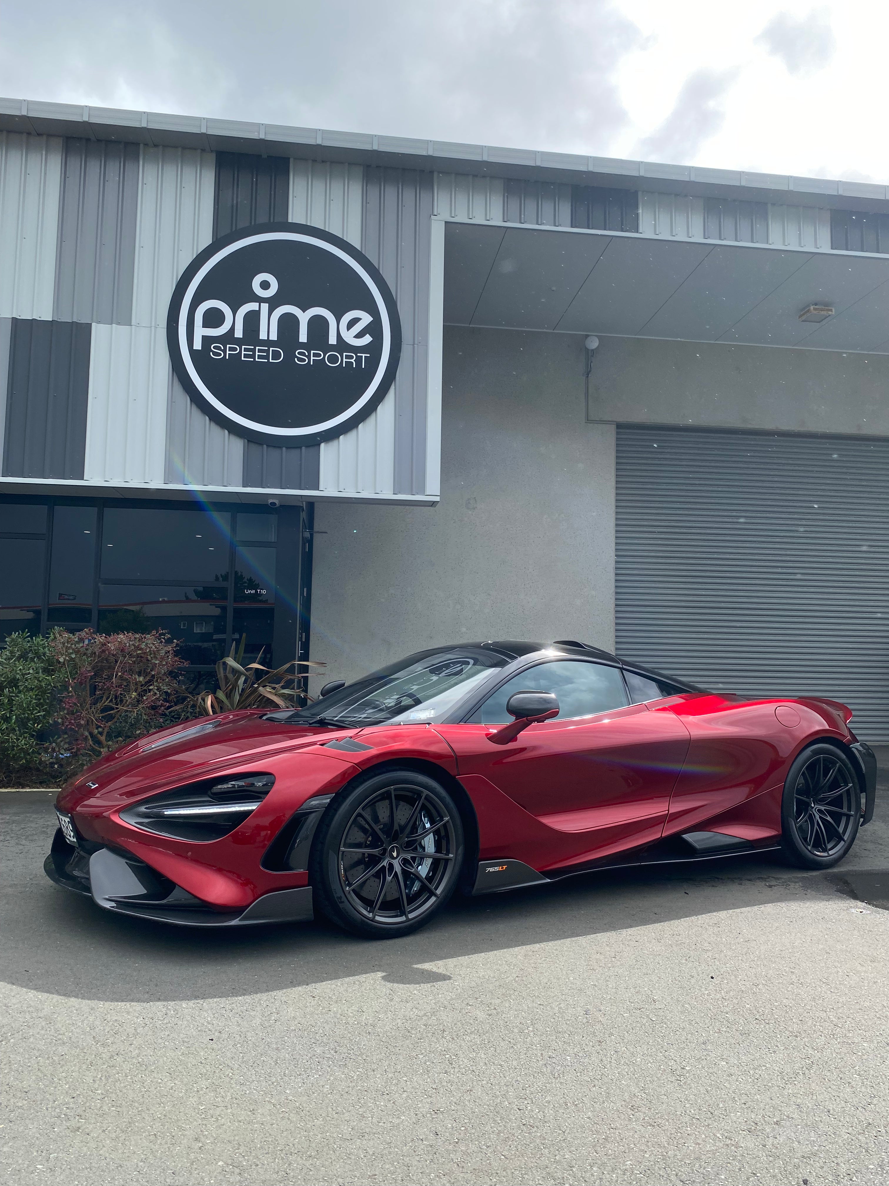 Front 3/4 view of 2021 McLaren 765LT For Sale by Prime Speed Sport in New Zealand. Highly specced with full carbon pack and finished in MSO optioned Volcano Red exterior paint.