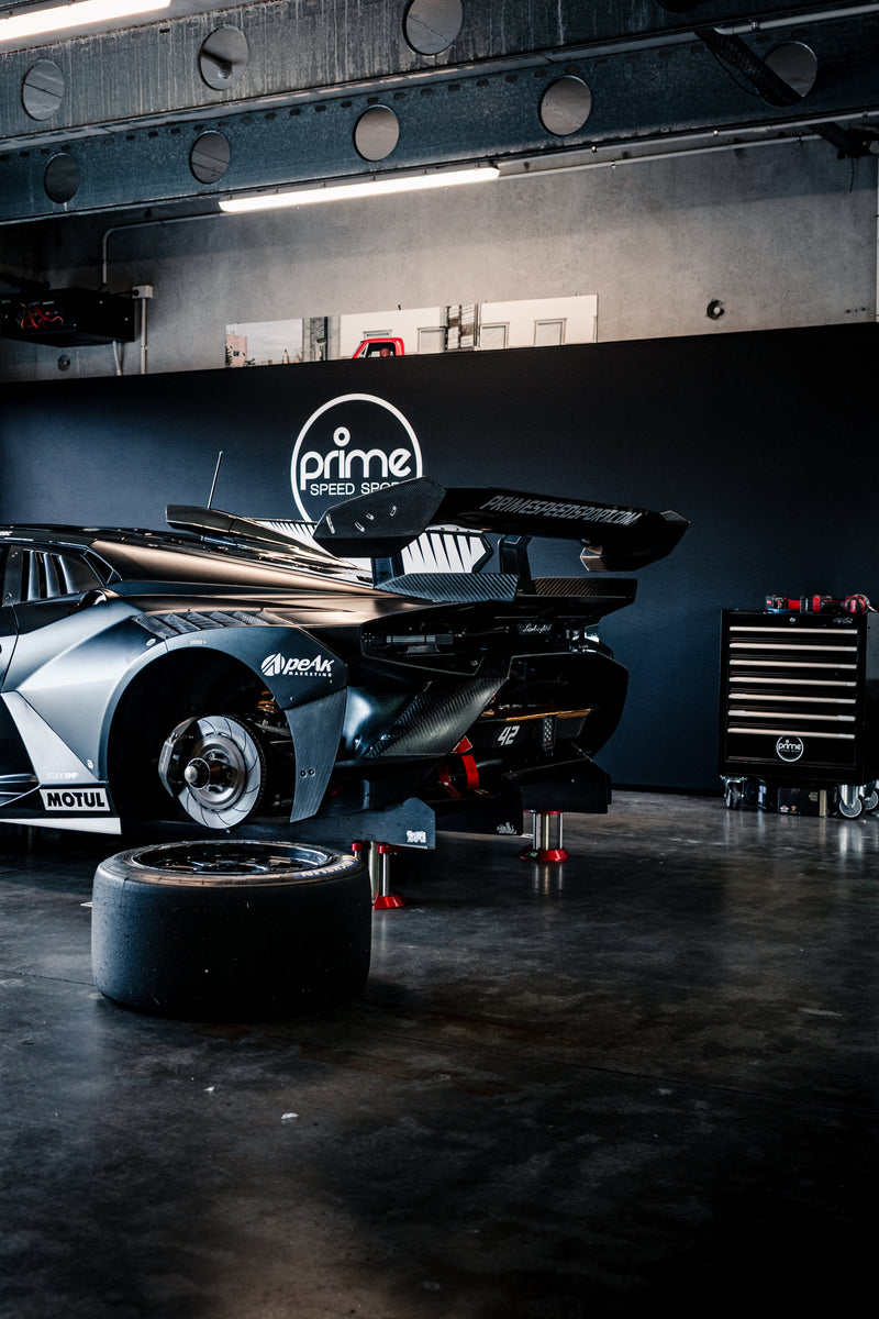 Prime Speed Sport garage at Hampton Downs Motorsport Park with Prime branding and equipment. Black Lamborghini Super Trofeo inside the garage with the Tyres off of the car. SP Tools toolbox in the background.