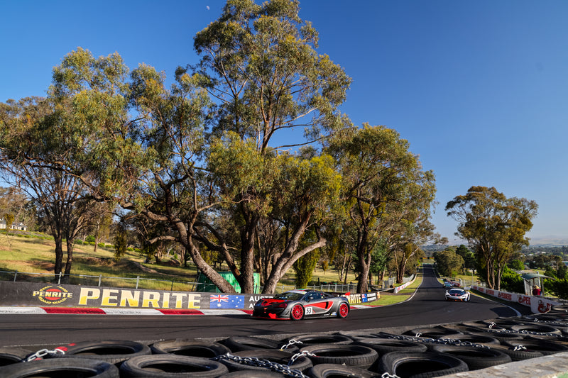 Red and Black McLaren 570 racing at Challenge Bathurst at Mount Panorama