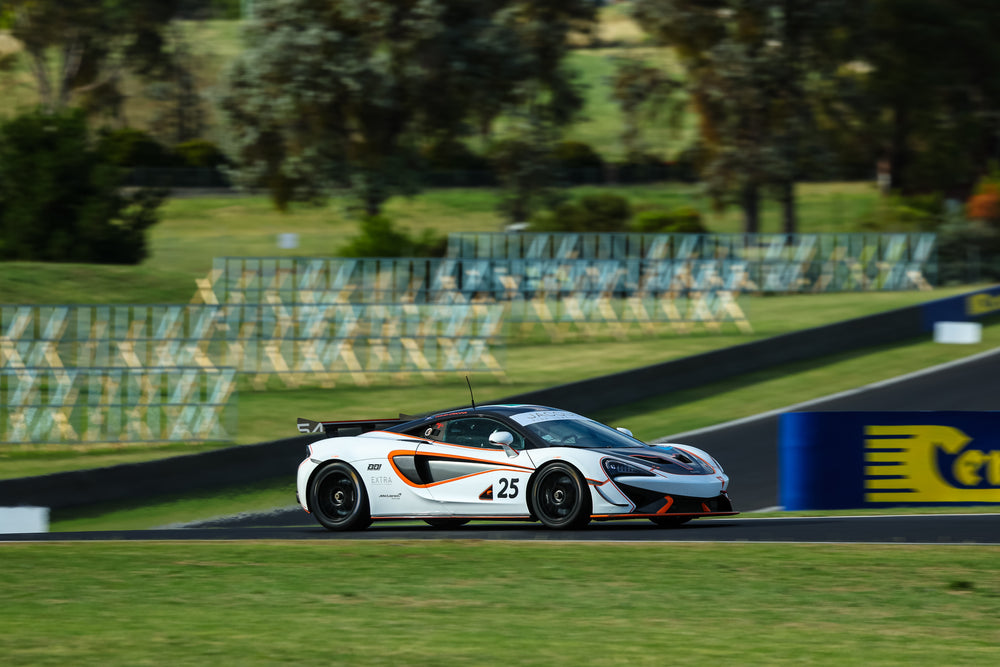White and orange McLaren 570S GT4 race car with number 25 competing at Challenge Bathurst, supported by Prime Speed Sport.