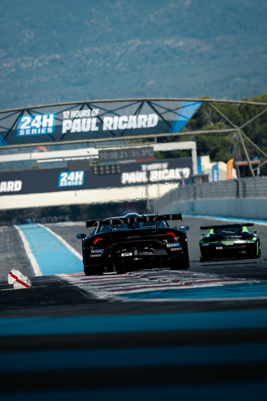 Black Lamborghini Huracán GT3 Evo II and a green racing car competing in the 12 Hours of Paul Ricard endurance race, organized by the 24H Series.