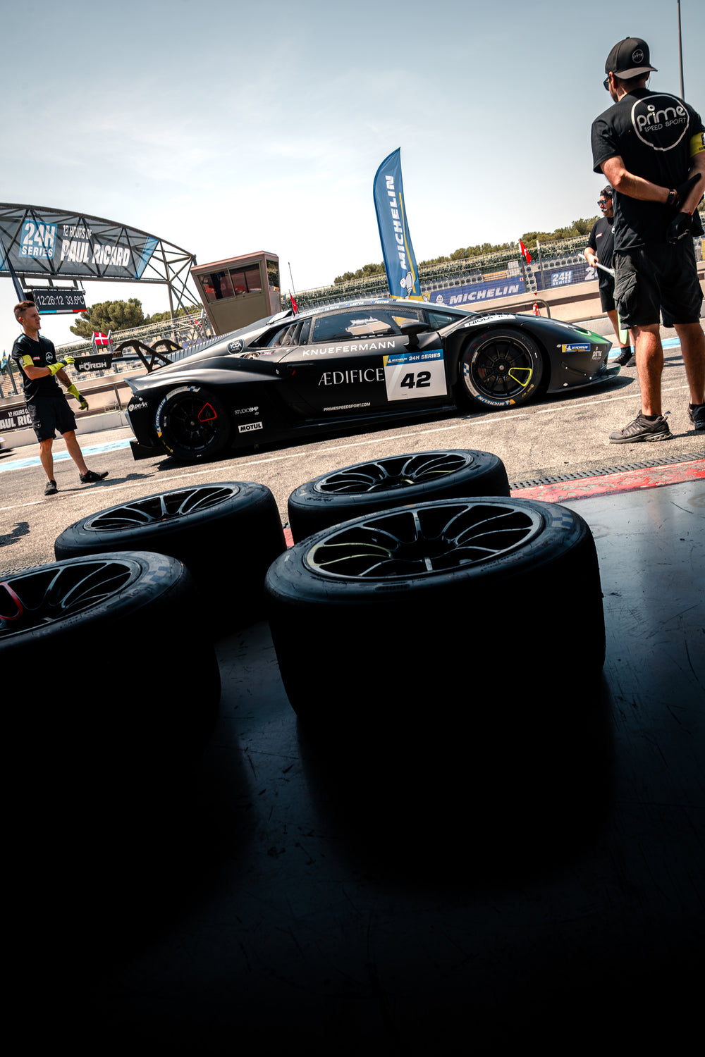 Laborghini Huracan Racing car with visible branding on a track, surrounded by tires.