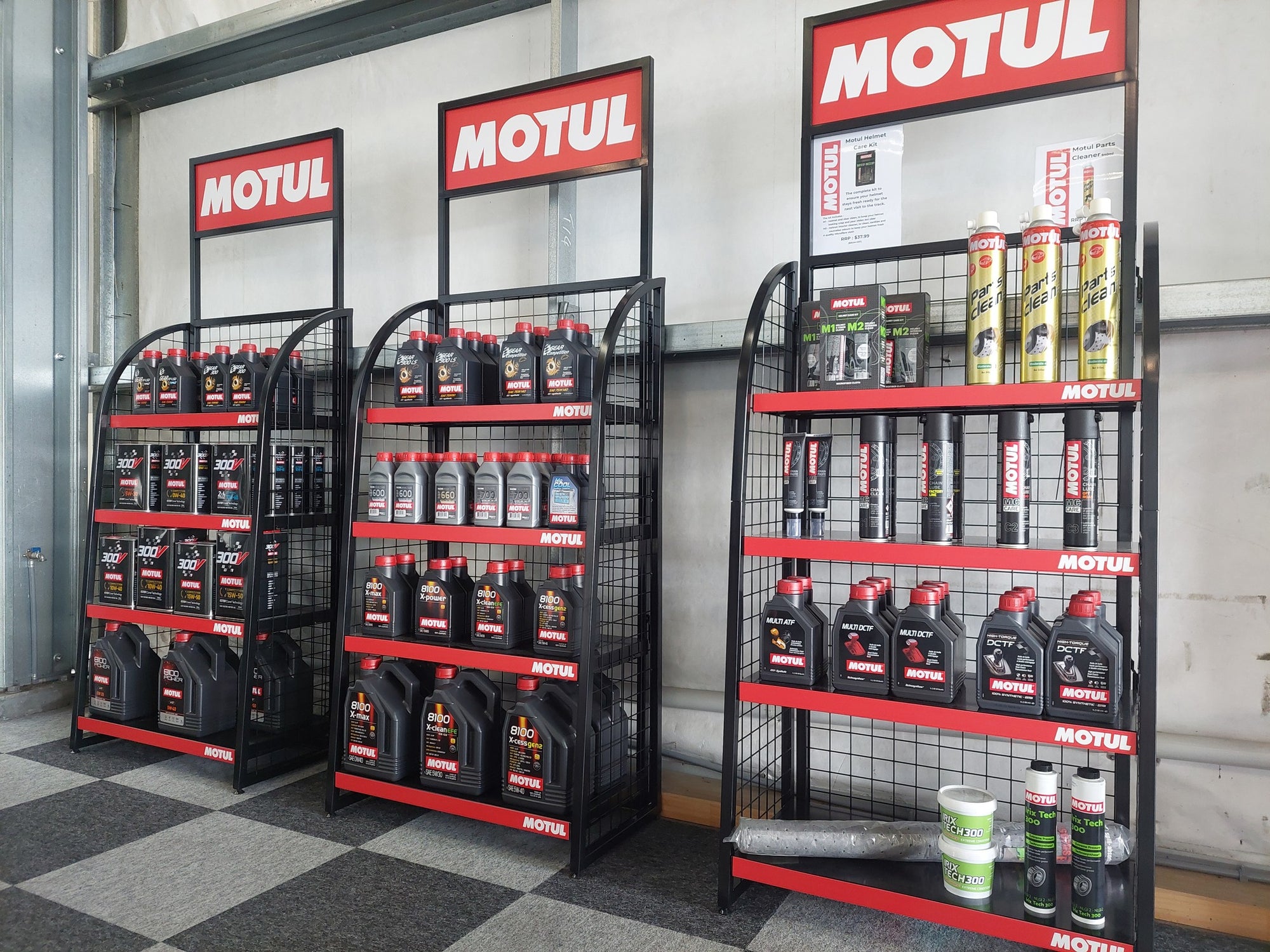 Display of Motul oil products on shelves in a store setting.